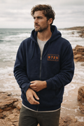 Man wearing the 6725 Zip Up Men's Hooded Jacket on the beach, showcasing its style and comfort.