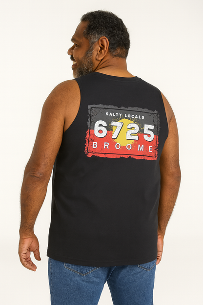 Man wearing a black sleeveless shirt with aboriginal flag on the back, standing against a white background.