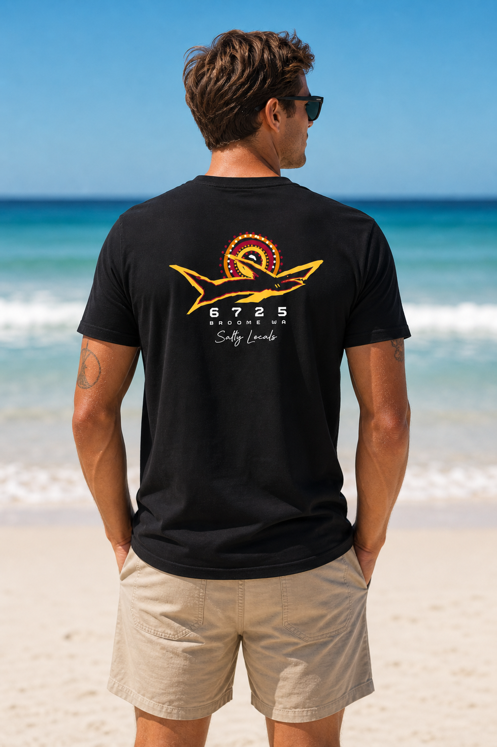 Men's "Salty Locals" Shark T-Shirt - Black | 6725 Broome with unique shark logo worn on beach.