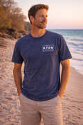 Men's Stonewash T-Shirt worn by a man on the beach during sunset, showcasing its blue color and casual style.