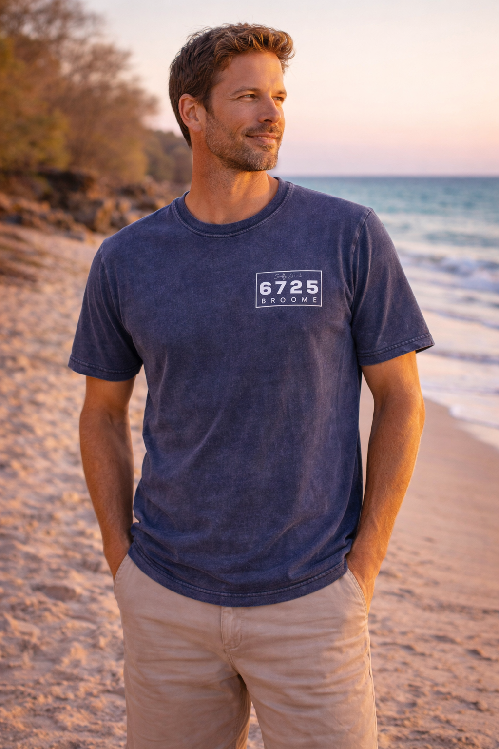 Men's Stonewash T-Shirt worn by a man on the beach during sunset, showcasing its blue color and casual style.