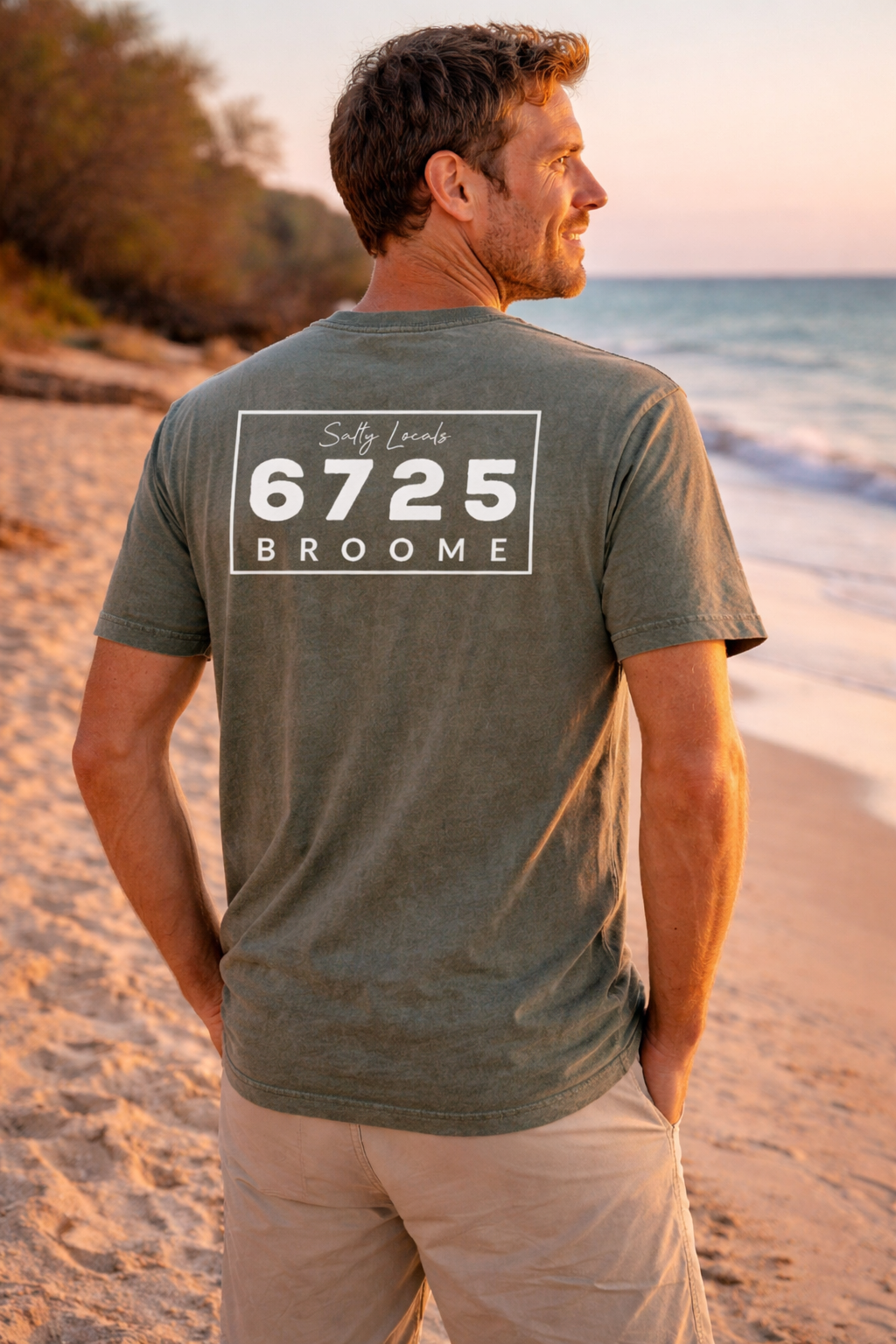 Men's Stonewash T-Shirt Moss 6725 Broome worn by man on beach at sunset, showcasing coastal style.